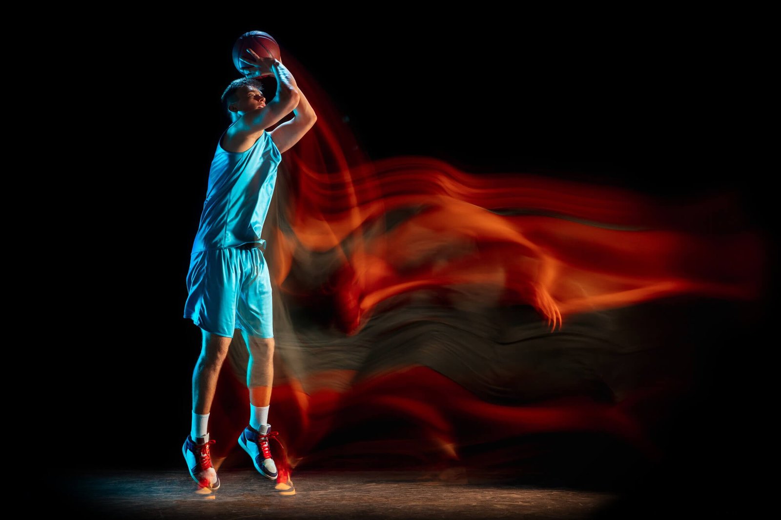 male-basketball-player-playing-basketball-isolated-dark-studio-wall-mixed-light